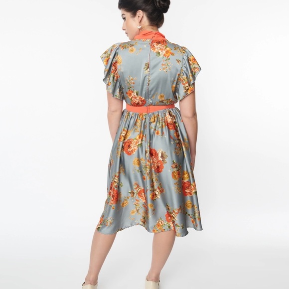 This swing dress is crafted in a blue satin fabric, adorned with orange florals. - Picture 3 of 4
